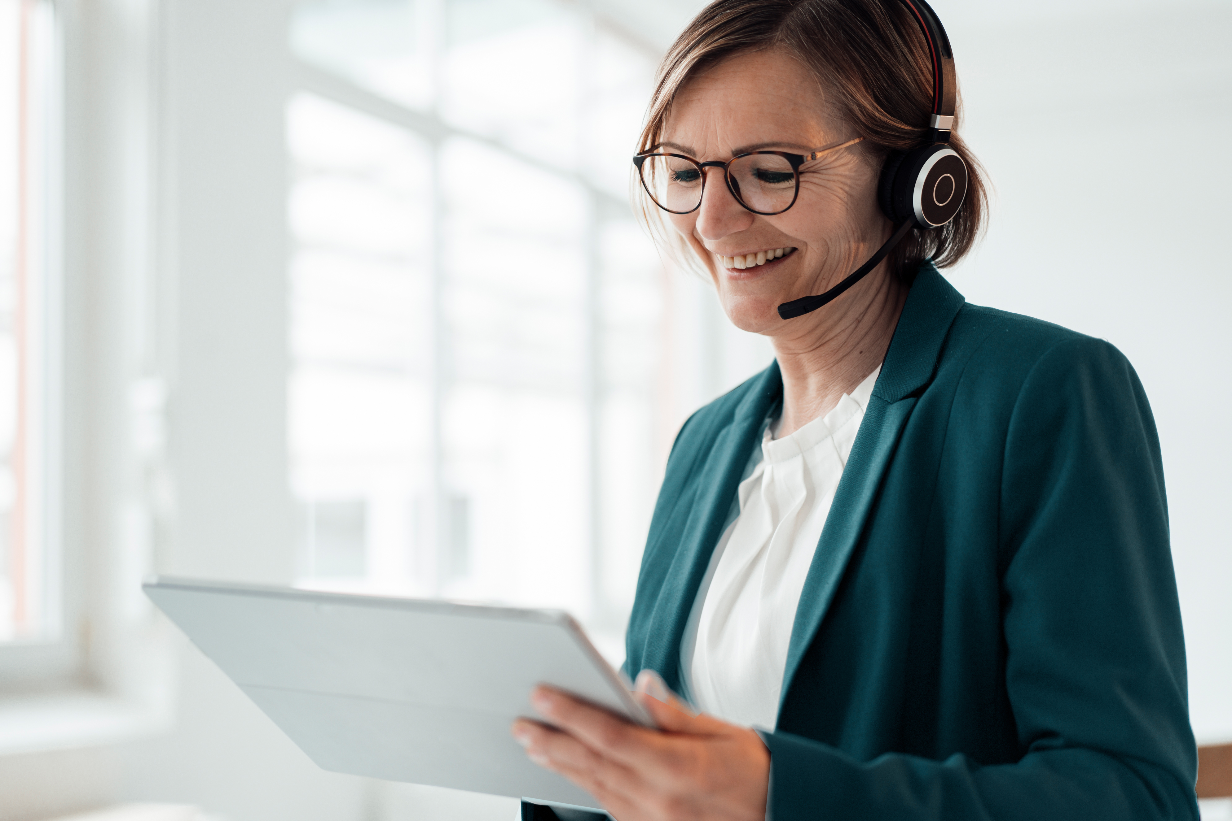 Bild zur Glasfaser-Hotline lächelnde Frau mit Headset und Tablet