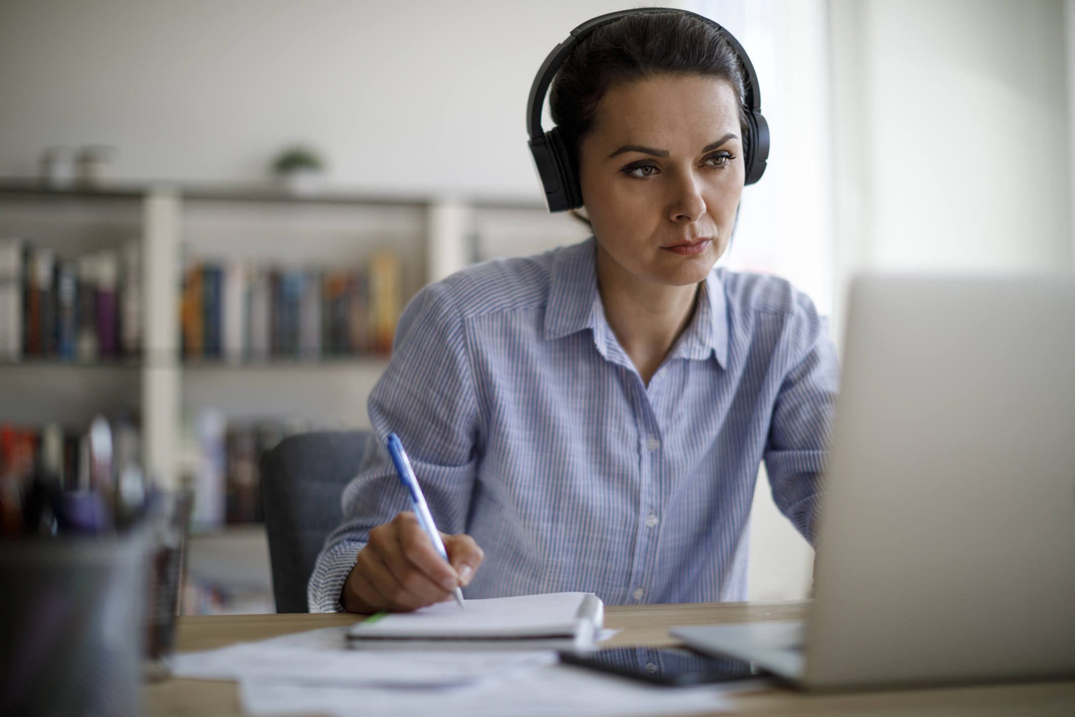 Frau arbeitet im Home-Office mit Cloud-Telefon über Headset