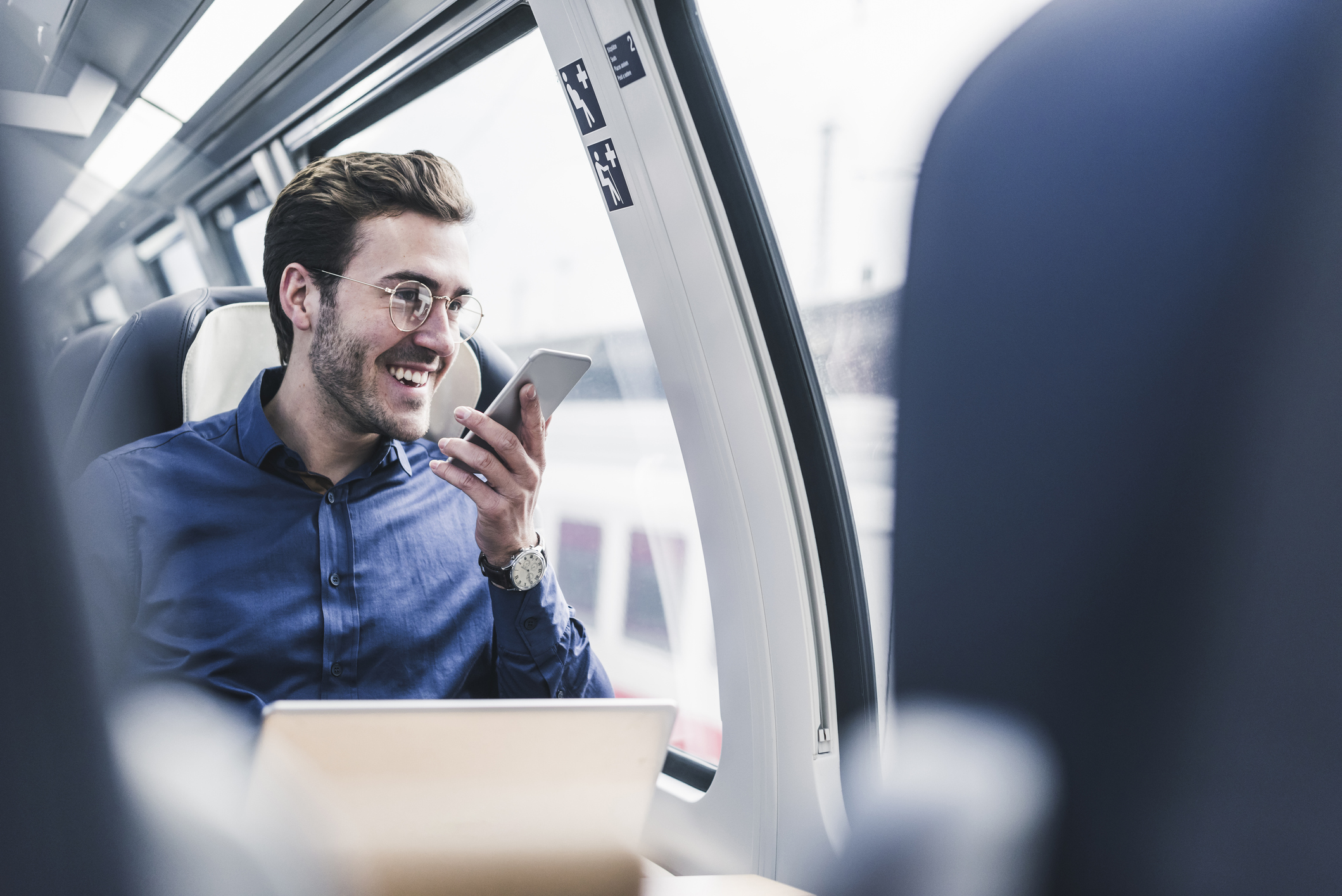 Mann telefoniert im Zug - Beispiel für Fixed Mobile Convergence
