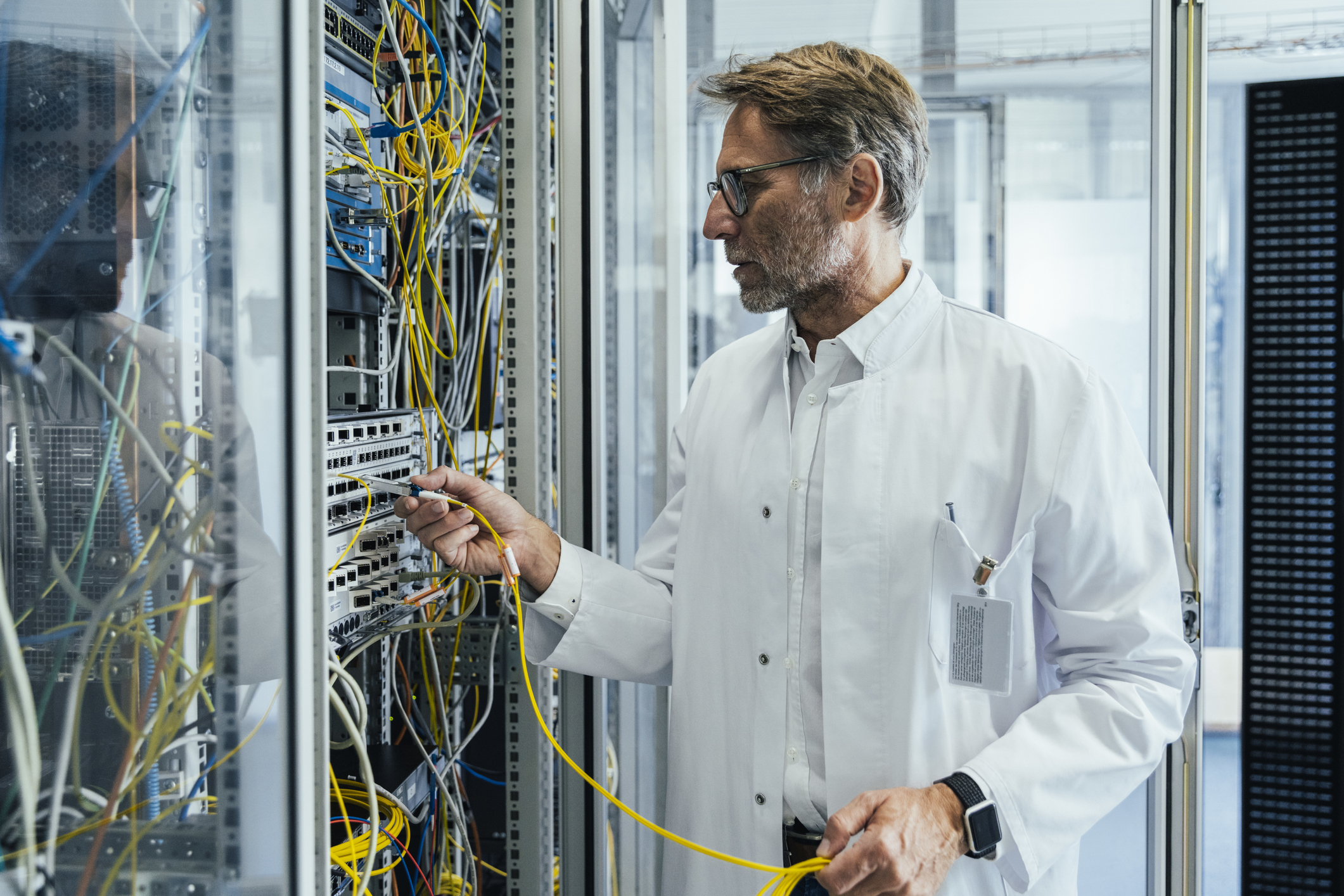 Mann im Serverraum mit Kabel in der Hand sorgt für Sicherheit der Cloud-Telefonie durch aktuelle Technik und Updates