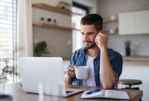 Young man with computer sitting at the table. Bild: © Halfpoint Images / Getty Images